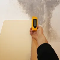 Measuring moisture on a stained wall with a digital moisture meter