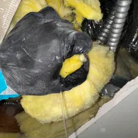 Wet fiberglass insulation being removed from a ceiling cavity