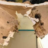 Water-damaged ceiling opened up after a leak to dry the cavity